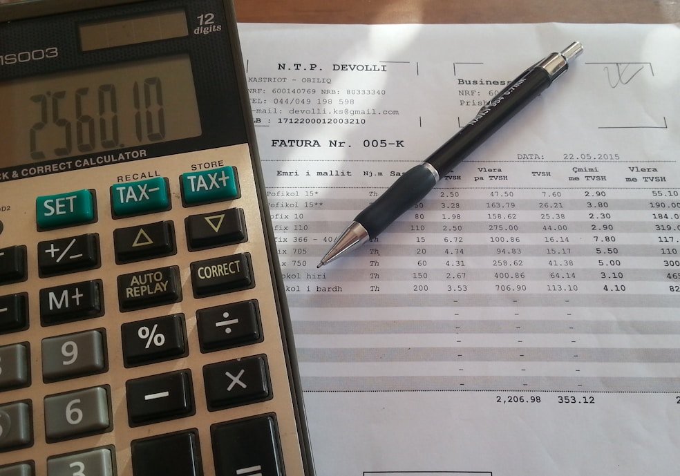 A calculator and business invoice on a desk